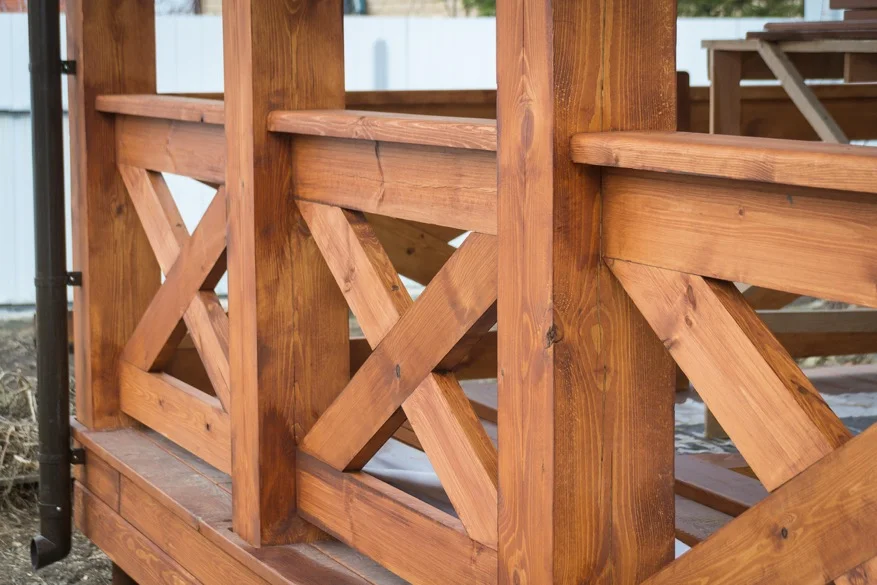 the railing of a deck up close after being recently stained